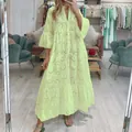 Gros plan sur une robe longue vert tilleul en dentelle ajourée avec col en V et manches cloches - S / Robes / Jaune