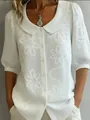 Detailed view of white floral embroidery on retro short sleeve button-down blouse - S / Tops / White