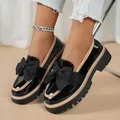 Détail de mocassins en cuir verni noir avec un nœud décoratif et une semelle épaisse à crampons - 36 / Noir