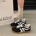 Retro black and white women's GAT sneakers with gum soles shown in a lifestyle scene - 35 / German Army Trainers / Black
