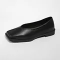 Primer plano detallado de un zapato plano negro clásico con elegante diseño en V - Negro