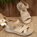 Detail of women's khaki flat sandals featuring woven cross straps and adjustable velcro. - 36 / Beige