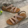 Close-up view of women's flat sandals with elastic cross-straps on concrete stairs - 36 / Khaki