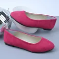 Dettaglio delle ballerine in camoscio rosa vibrante in un moderno set da studio con specchio. - Rosso rosa
