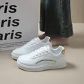 Detail shot of white platform sneakers with gold accents and lace-up closure - 38 / White Gold