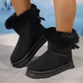 Close-up of black winter snow boots with plush trim and decorative bowknot details - 36 / Black