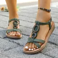 Detailed view of women's olive green Roman sandals featuring wooden ring accents and elastic straps - 36 / Green