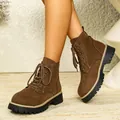 Detailed view of brown suede platform Martin ankle boots worn for a stylish look. - 36 / Brown