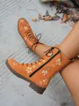 Close-up of orange mid-calf boots with intricate floral embroidery and side zipper - 36 / Orange