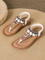 Detailed view of Bohemian flat sandals with colorful beads and white T-strap design. - 36 / Milky White