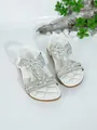 Detailed view of white flat sandals with sparkling rhinestone flower embellishments - White