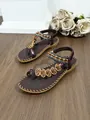 Close-up detail of Bohemian flat sandals featuring ethnic beads and heart-shaped embroidery. - 38 / Coffee