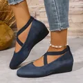 Close-up of blue suede wedge shoes with criss-cross straps on a model - 36 / Blue