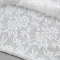 Vista macro dell'intricata trama in pizzo floreale bianco e dettaglio traforato - Taglia S / Top / Bianco