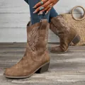 Detailed shot of brown suede western boots with intricate white floral embroidery - 36 / Tan