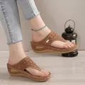 Close-up detail of brown wedge thong sandals featuring intricate hollow-out patterns - 35 / Tan