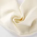 Detailopname van de hoogwaardige roomwitte blazerstof met een fijne weving en soepele val. - S / Tops / Abrikoos