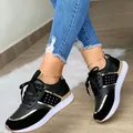 Detailopname van stijlvolle zwarte dames sneakers met gouden accenten en een dikke zool. - 35 / Zwart