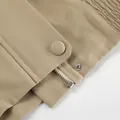 Detailansicht von Reißverschluss und Druckknopf an einem minimalistischen khakifarbenen Mantel - S / Oberteile / Khaki