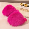 Vibrant fuchsia fluffy faux fur slippers shown from a high angle on a cozy white rug - Rose Red