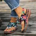 Detailaufnahme der Keilsandalen mit ethnischem Blumenstickmuster auf Holzdeck - 36 / Blumiges Schwarz