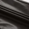 Gros plan montrant la texture et le grain du tissu en similicuir marron foncé mat haut de gamme - S / Bas / Marron