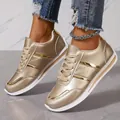 Detail of gold metallic sneakers for women with white soles and laces worn by a model. - 36 / Gold
