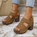 Detailaufnahme von braunen Plateausandaletten für Damen mit Goldnieten und Schnalle - 36 / Braun