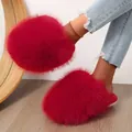 Close-up detail of vibrant red fluffy faux fur slippers with closed-toe winter design. - Red