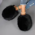Close-up of black oversized fluffy faux fur slippers worn with blue ripped jeans - 36-37 / Black
