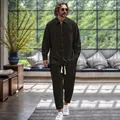 Reifer Mann im dunklen Baumwoll-Leinen-Set in modernem, sonnigem Interieur - Schwarz