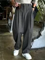 Dettaglio dei pantaloni da abito larghi a pieghe da uomo in un'elegante finitura grigio scuro - Grigio scuro