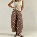 Detail shot of brown polka dot barrel jeans showing curved leg fit and pattern. - S / Bottoms / Auburn