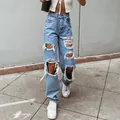 Detailed view of light blue ripped straight-leg jeans in a street style setting - Light Blue