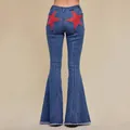 High-waisted blue stretch denim flare jeans featuring large red star patchwork on the back. - S / Bottoms / Blue