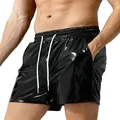A detailed view of men's shiny black faux leather leisure shorts featuring white drawstrings. - S / Bottoms / Black
