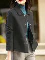 Vista dettagliata di un'elegante giacca di lana nera con bottoni a pressione su una modella. - Taglia S / Top / Grigio scuro