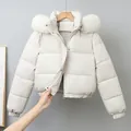 Women's short white puffer jacket featuring a plush faux fur hood for winter warmth - White