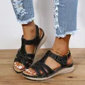 Detailed view of women's black crossover wedge sandals with white contrast stitching - 36 / Black