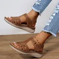 Detailed macro view of retro brown cross-strap wedge sandals with contrast stitching - 36 / Dark Brown