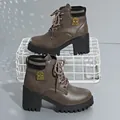 Detail view of brown chunky heel Martin boots with knitted collar and metal emblem. - 35 / Gray