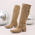 Close-up detail of stylish tan suede tall boots with decorative silver buckle straps - 35 / Apricot