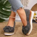Close-up detail of grey women's wedge platform loafers with decorative bow on mat - 36 / Gray