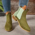 Detail shot of green suede pointed-toe ankle boots with elastic side panels. - Green