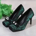 Detailed view of elegant teal and black lace stiletto pumps with square toe and jeweled bow - 34 / Green