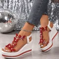 Nahaufnahme weißer Plateausandalen mit roten Glitzerschmetterlingen und funkelnden Strasssteinen - Rot