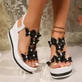 Detail of white wedge sandals with black sequin butterflies and rhinestone platform sole. - Black and White