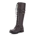 Close-up of brown knee-high riding boots with decorative buckles and laces - Coffee