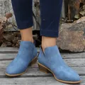 Close-up van blauwe suède enkellaarsjes met puntige neus gedragen met jeans in buitenlucht. - Hemelsblauw