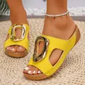 Close-up of yellow wedge sandals featuring a large gold metal buckle and open toe - Yellow